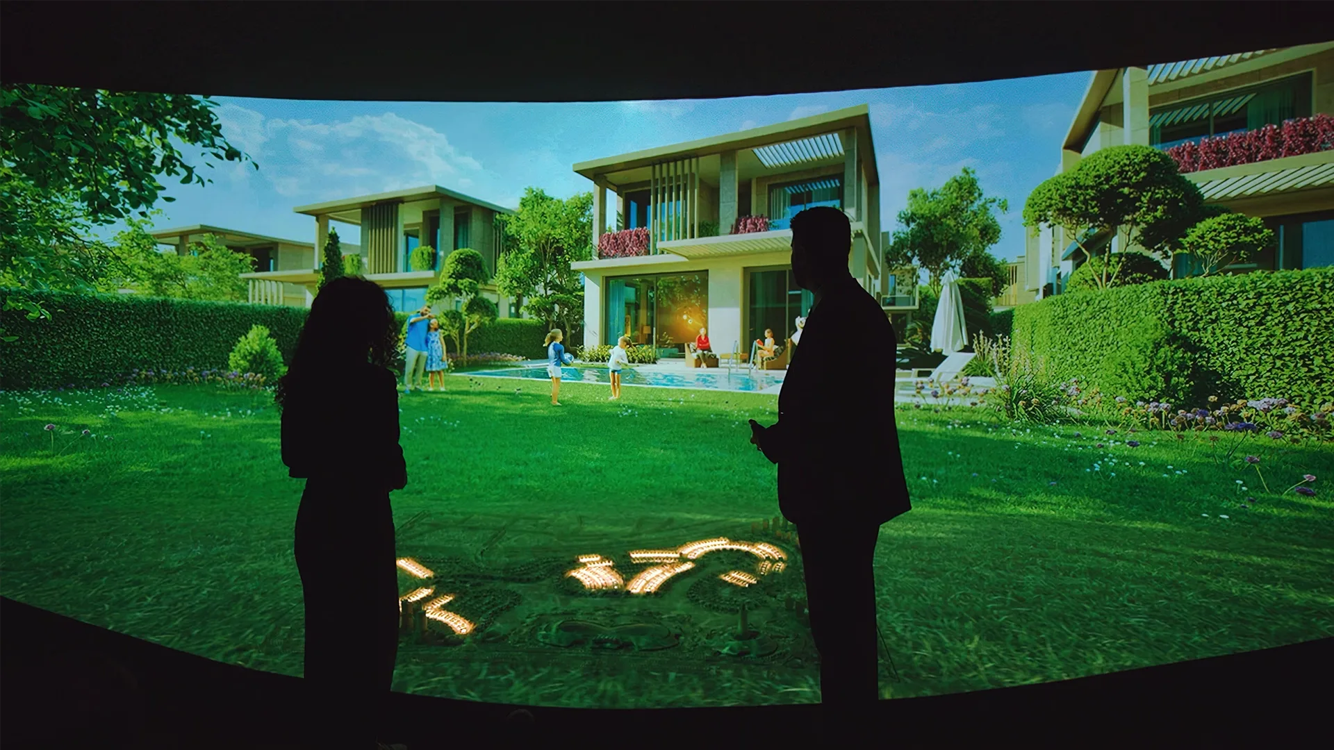 Concave projection screen showing the villas and garden